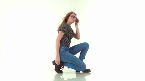 Belle fille aux cheveux roux avec des lunettes sur fond blanc 