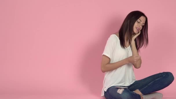 ヘッドフォンを通して音楽を聴く若い女性 — ストック動画