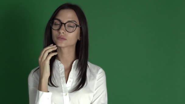 Joven mujer de belleza en gafas. Mujer en gafas redondas sobre un fondo verde brillante cámara lenta — Vídeo de stock