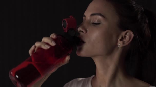 Тонкая молодая женщина пьет воду после тренировки. — стоковое видео