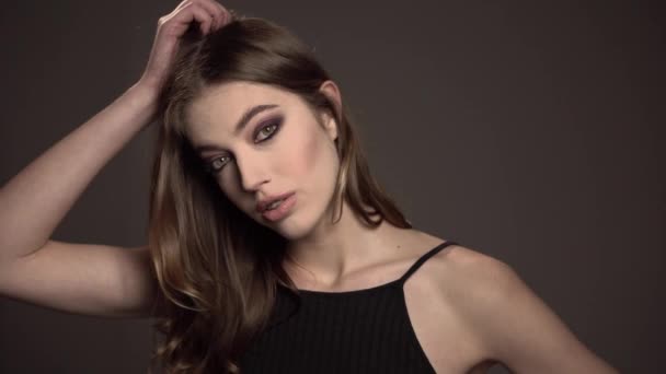 Modelporträt, Mädchen mit braunen Augen und ausdrucksstarkem Mund, auf schwarzem Hintergrund — Stockvideo
