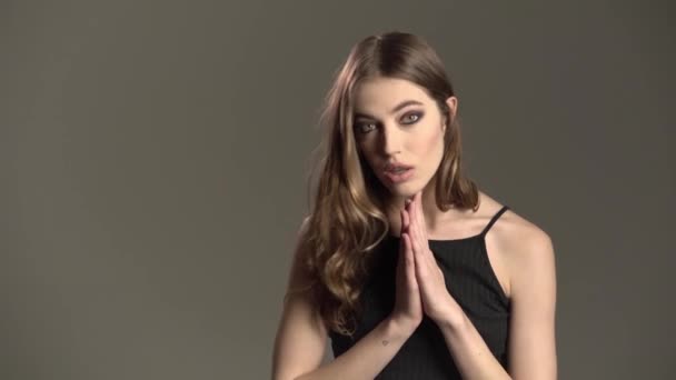 Modelporträt, Mädchen mit braunen Augen und ausdrucksstarkem Mund, auf grauem Hintergrund — Stockvideo