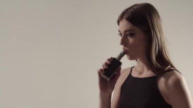 Bir gri arka plan vaping e-sigara bir Buharlaştırıcı kızla