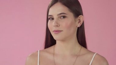 Uzun saçlı güzel moda kız. Kız pembe bir arka plan üzerinde stüdyoda. Reklam, saç ürünleri, güzellik salonları, kozmetik, giyim. Moda, butik. Pembe.