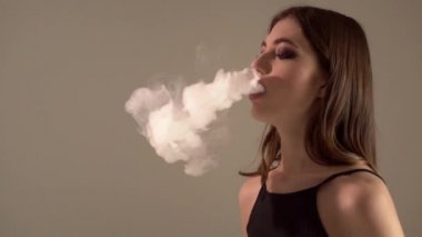 Bir gri arka plan vaping e-sigara bir Buharlaştırıcı kızla