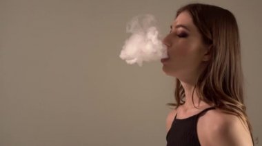 Bir gri arka plan vaping e-sigara bir Buharlaştırıcı kızla