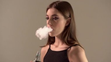 Bir gri arka plan vaping e-sigara bir Buharlaştırıcı kızla