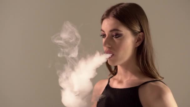 Bir gri arka plan vaping e-sigara bir Buharlaştırıcı kızla — Stok video