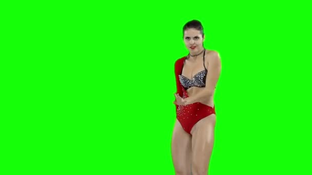 A girl in a red swimsuit is dancing, on a green screen — Stock Video