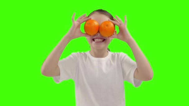 Menina feliz segura metade de laranja perto do rosto — Vídeo de Stock