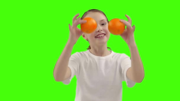 Glad tjej håller hälften av orange nära ansiktet — Stockvideo