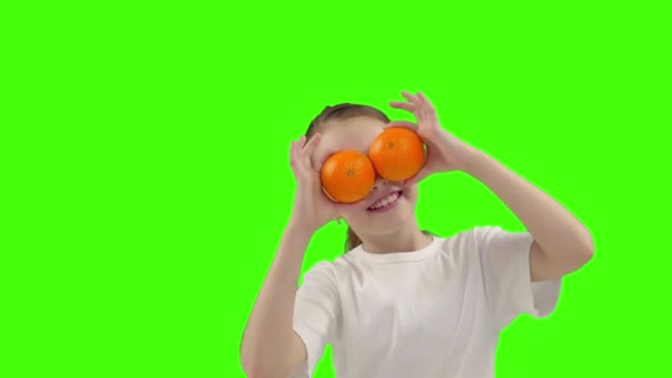 Menina feliz segura metade de laranja perto do rosto — Vídeo de Stock