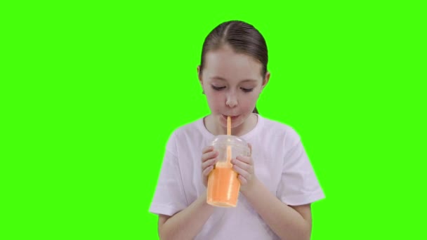 Fin jente som drikker gjennom en halmdrikk. Grønn skjerm – stockvideo