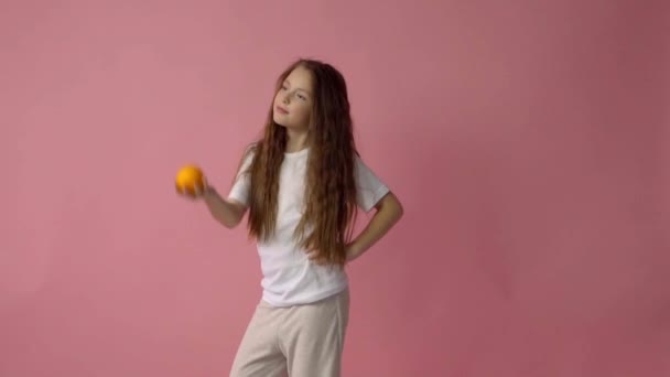 The little girl holds orange — Stock Video