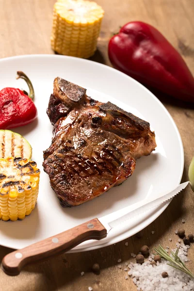 Gegrilde steak op bruin houten oppervlak — Stockfoto