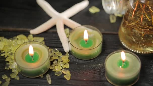 Velas verdes en el salón de spa y aceite de masaje — Vídeo de stock