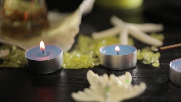 Grüne Kerzen im Wellness-Salon und Massageöl — Stockvideo