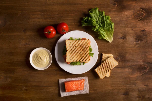 Клубный сэндвич с рыбой на деревянной доске — стоковое фото