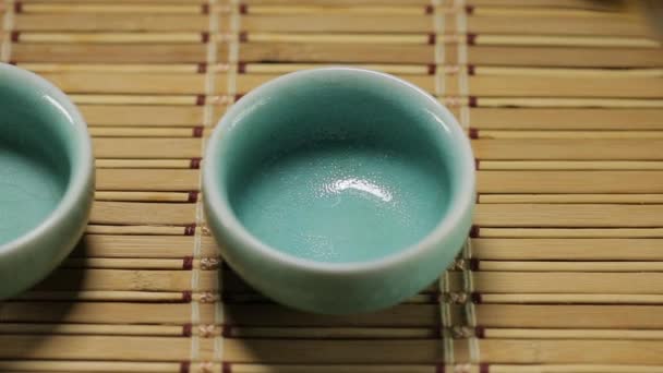 Grüner Tee gießt in asiatische Tasse — Stockvideo