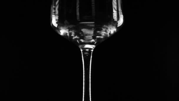 Water giet in transparant glas op de zwarte achtergrond — Stockvideo