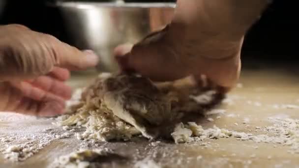 Baker kneading dough in flour on table — Stock Video