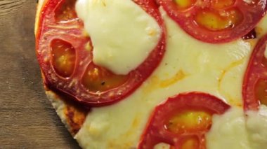 Bir dilim pizza alıyor, erimiş peynir damlıyor.