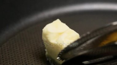 Tereyağı bir düğme sıcak siyah kızartma tava içine koymak ve erir