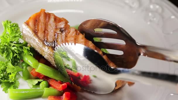 Put prepared grilled salmon fillets on the plate — Stock Video