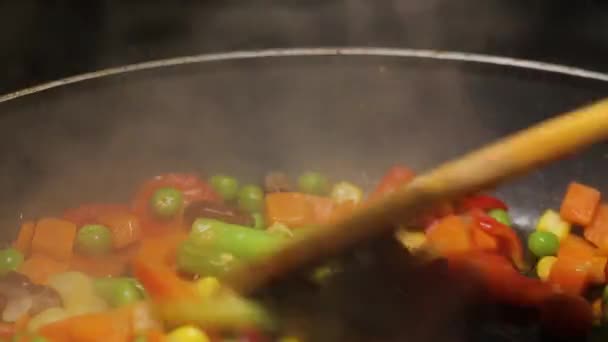 Légumes frits colorés sur une poêle close-up. La vapeur monte. — Video