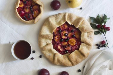 Hamur ve Erik beyaz masa örtüsü üzerinde hazırlanan geleneksel rustik kek