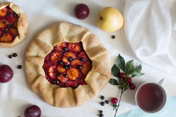 Hamur ve Erik beyaz masa örtüsü üzerinde hazırlanan geleneksel rustik kek