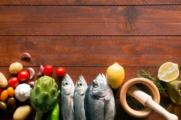 Свіжа органічна їжа - природна морська риба та овочі на дерев'яній поверхні — стокове фото