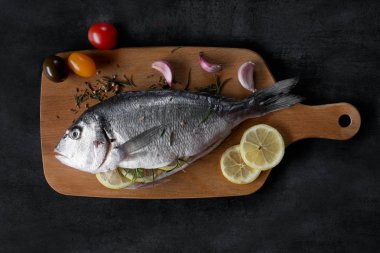Akdeniz balık - dorado ve sebze kesme tahtası üzerinde. Üstten Görünüm.