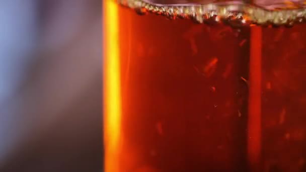 Cervejando chá em um jarro - Folhas de chá flutuando na decocção do chá — Vídeo de Stock