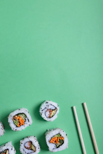 Ιαπωνική Σούσι σε πράσινο φόντο. Ρολά και τα Τσοπ στικς — Φωτογραφία Αρχείου