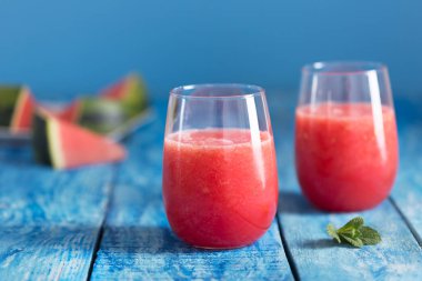 Mavi ahşap rustik arka plan üzerinde iki bardak taze karpuz smoothie