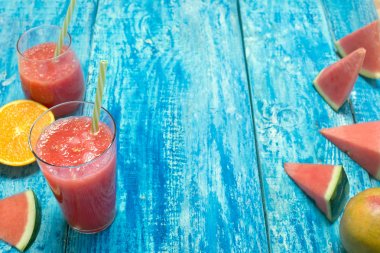 Taze multivitamin güler yüzlü çubuk mavi ahşap rustik arka plan üzerinde ile iki bardak