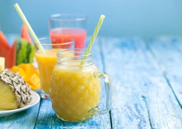 Mavi ahşap rustik arka plan üzerinde üç bardak taze ananas ve karpuz smoothie — Stok fotoğraf