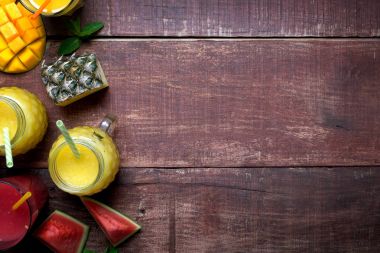 Gözlük ile kopya alanı sağ ile ahşap rustik arka plan üzerinde meyve taze ananas ve mango smoothie