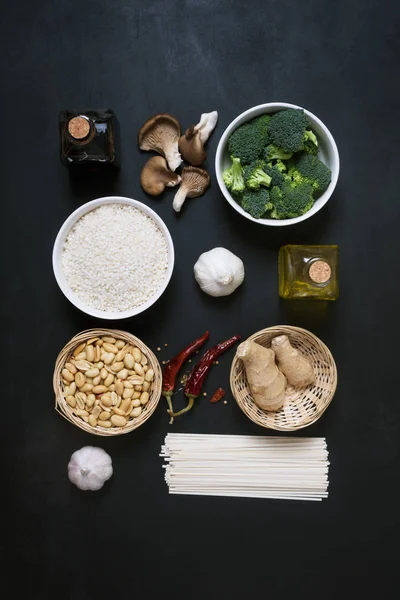 Chinese food raw ingredients, vegetables and nuts on the dark background. Flat lay