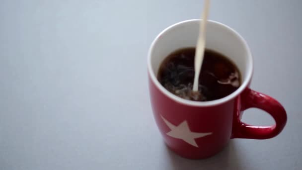 Крем наливается в чашку кофе — стоковое видео