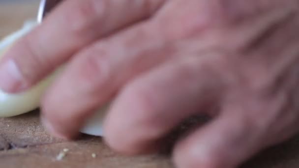 Homme coupant l'oeuf cuit sur la planche à découper avec le couteau Fermer . — Video