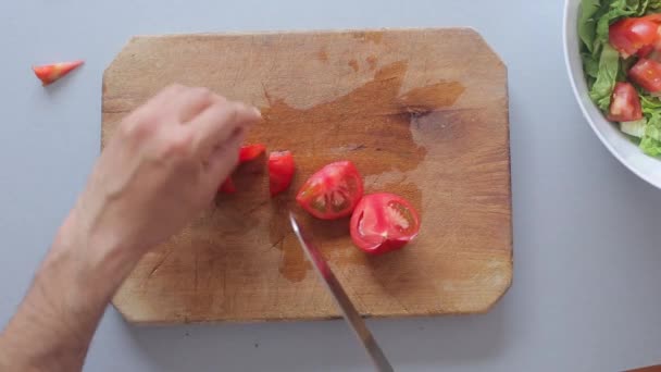 Кухарські руки готують салат на дерев'яній обробній дошці — стокове відео