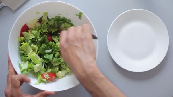 Руки шеф-повара кладут салат в миску — стоковое видео