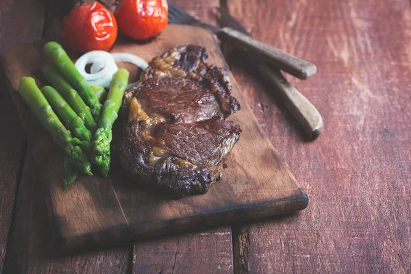 Gegrilltes Rindersteak auf rustikalem Holzboden — Stockfoto