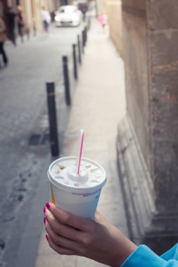 Plastik bardak bir saman ve bir el ile