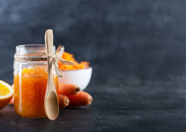 Siyah zemin üzerinde portakal suyu olan havuç reçeli.