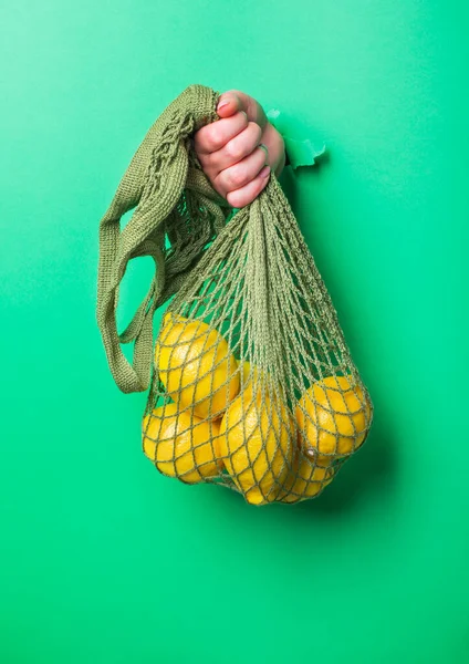 A woman holds reusable Cotton String Portable Shopping Handbag with lemons