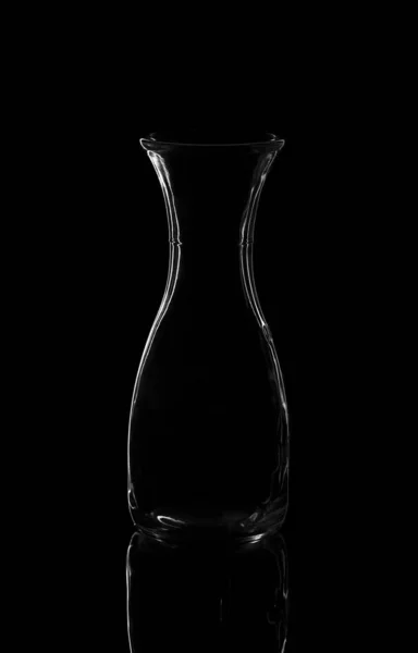 Empty bottle or decanter isolated on a dark background — Stock Photo, Image