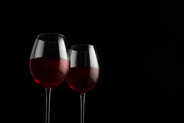 검은 배경에 빨간 와인 잔 두 개 — 스톡 사진